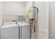 Laundry room with washer, dryer, water heater, and shelving at 7554 Sunflower Cir, Kissimmee, FL 34747
