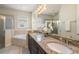 Bright bathroom featuring double sinks, granite countertops, and a separate shower and tub at 7616 Brookhurst Ln, Kissimmee, FL 34747