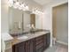 Bright bathroom featuring double sinks with granite counters and updated cabinets at 7616 Brookhurst Ln, Kissimmee, FL 34747