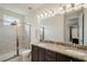 Bright bathroom featuring double sinks, granite countertops, and a glass-enclosed shower at 7616 Brookhurst Ln, Kissimmee, FL 34747