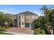 Charming two-story home with a well-maintained lawn, brick driveway, and a two car garage at 7616 Brookhurst Ln, Kissimmee, FL 34747