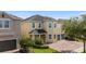 Charming two-story home with a well-maintained lawn, brick driveway, and a two car garage at 7616 Brookhurst Ln, Kissimmee, FL 34747