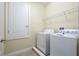 Convenient laundry room featuring a full-size washer and dryer and ample storage space at 7616 Brookhurst Ln, Kissimmee, FL 34747
