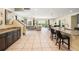 Open-concept kitchen, dining, and living area with tile floors and abundant natural light at 7616 Brookhurst Ln, Kissimmee, FL 34747