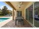 Covered patio with a long table, perfect for entertaining, overlooking the pool and backyard at 7616 Brookhurst Ln, Kissimmee, FL 34747
