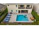 Aerial view of the backyard featuring a private pool, spa, lounge chairs, and outdoor dining area at 7616 Brookhurst Ln, Kissimmee, FL 34747