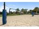 Outdoor sand volleyball court with net and palm trees creating a tropical recreational setting at 7616 Brookhurst Ln, Kissimmee, FL 34747