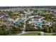Birds-eye view of a waterpark featuring pools, slides, and a building, nestled among residences in a planned community at 7616 Brookhurst Ln, Kissimmee, FL 34747