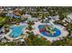 Overhead aerial capture of a waterpark with pools, slides, and sunbathing areas, nestled within a residential community at 7616 Brookhurst Ln, Kissimmee, FL 34747