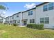 A well-maintained backyard with green grass extends behind a row of townhomes at 955 Grandin St, Davenport, FL 33837