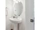 Bathroom with pedestal sink, modern faucet, and large oval mirror at 955 Grandin St, Davenport, FL 33837