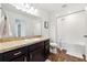 Well-lit bathroom features a single sink, dark wood cabinets, and shower over tub at 955 Grandin St, Davenport, FL 33837