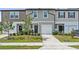 Inviting townhome showcasing a well-maintained lawn, charming shrubbery, and a private garage at 955 Grandin St, Davenport, FL 33837