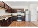 Modern kitchen with stainless steel appliances, granite countertops, and dark wood cabinets at 955 Grandin St, Davenport, FL 33837