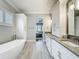Bright bathroom with soaking tub, shaker cabinets, grey countertops, and tiled floors at 960 Civitas Way, Winter Garden, FL 34787