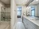 Hallway view of the bathroom featuring tiled shower with glass door and double sink vanity at 960 Civitas Way, Winter Garden, FL 34787