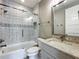 Well-lit bathroom featuring a tiled shower with glass door, white toilet, and vanity with granite countertop at 960 Civitas Way, Winter Garden, FL 34787
