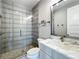 Bathroom with tiled shower and glass door, marble countertop and modern lighting fixtures at 960 Civitas Way, Winter Garden, FL 34787