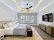 Bright, airy bedroom with a tray ceiling, a large bed, and modern furnishings at 960 Civitas Way, Winter Garden, FL 34787