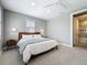 Bright bedroom featuring a wooden bed frame, ceiling fan, and ensuite bathroom behind a partially opened door at 960 Civitas Way, Winter Garden, FL 34787