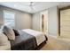 Neutrally decorated bedroom featuring a ceiling fan, double-paned window and ensuite bathroom through door at 960 Civitas Way, Winter Garden, FL 34787