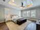 Serene bedroom with tray ceiling, dark wood floors and plantation shutters at 960 Civitas Way, Winter Garden, FL 34787