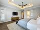 Spacious bedroom with a tray ceiling, and a sliding door leading to a bathroom at 960 Civitas Way, Winter Garden, FL 34787