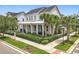Charming two-story home with a metal roof, inviting front porch, well-manicured landscaping, and palm tree accents at 960 Civitas Way, Winter Garden, FL 34787