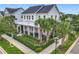Charming two-story home with a metal roof, inviting front porch, well-manicured landscaping, and palm tree accents at 960 Civitas Way, Winter Garden, FL 34787