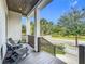 This is a view of the home's covered front porch area with chairs and a wood ceiling at 960 Civitas Way, Winter Garden, FL 34787