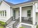 This front porch has white brick columns, a wood ceiling, gray railings, and comfortable seating area at 960 Civitas Way, Winter Garden, FL 34787