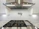 Gas cooktop with pot filler, stainless hood, and white subway tile backsplash at 960 Civitas Way, Winter Garden, FL 34787