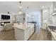 Open kitchen view to the living room showing large island, farm sink, and stainless appliances at 960 Civitas Way, Winter Garden, FL 34787