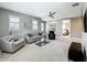 A stylish living room featuring a ceiling fan, neutral-toned walls, and cozy seating arrangements under natural light at 960 Civitas Way, Winter Garden, FL 34787