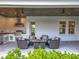 Relax in this outdoor patio featuring an outdoor kitchen, a seating area, and views of the backyard at 960 Civitas Way, Winter Garden, FL 34787
