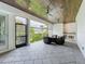 Enjoy this covered patio featuring a stone floor, wood ceiling, outdoor kitchen, and comfortable seating area at 960 Civitas Way, Winter Garden, FL 34787