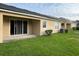Backyard view with sliding glass door, grassy lawn, and air conditioning unit at 9721 Old Patina Way, Orlando, FL 32832