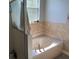 Bathroom featuring a deep soaking tub with tile surround, creating a serene and relaxing atmosphere at 9721 Old Patina Way, Orlando, FL 32832