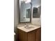 Bathroom featuring a vanity with wood cabinets, neutral countertop, and framed mirrors at 9721 Old Patina Way, Orlando, FL 32832