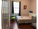 Cozy bedroom with hardwood floors, a window for natural light, and neutral wall paint at 9721 Old Patina Way, Orlando, FL 32832