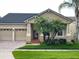 Attractive home with mature palm trees, a well-kept lawn, and a red front door at 9721 Old Patina Way, Orlando, FL 32832