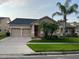 Charming single-Gathering home with well-maintained landscaping, lush lawn, and mature palm trees at 9721 Old Patina Way, Orlando, FL 32832