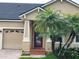 Charming home showcasing a brick paver driveway, mature palm trees, and a cozy front porch at 9721 Old Patina Way, Orlando, FL 32832