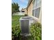 Outdoor AC unit in a well-maintained backyard with green grass and landscaping at 9721 Old Patina Way, Orlando, FL 32832