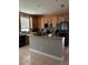 Well-lit kitchen features an island with tile floors and wooden cabinets at 9721 Old Patina Way, Orlando, FL 32832
