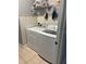 Bright laundry area with washer, dryer, storage shelves, and tiled backsplash for efficient cleaning at 9721 Old Patina Way, Orlando, FL 32832