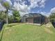 Lush backyard with a private screened lanai, palm trees, and scenic lake views enhance outdoor living at 9824 Secret Cove Ln, Orlando, FL 32832