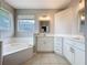 This bathroom features dual sinks, bathtub and a window with a view of the backyard at 9824 Secret Cove Ln, Orlando, FL 32832