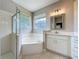 This bathroom features a tiled shower, a bathtub, and dual sink vanities at 9824 Secret Cove Ln, Orlando, FL 32832