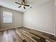 This bedroom has a ceiling fan, a window, and beautiful hardwood flooring at 9824 Secret Cove Ln, Orlando, FL 32832